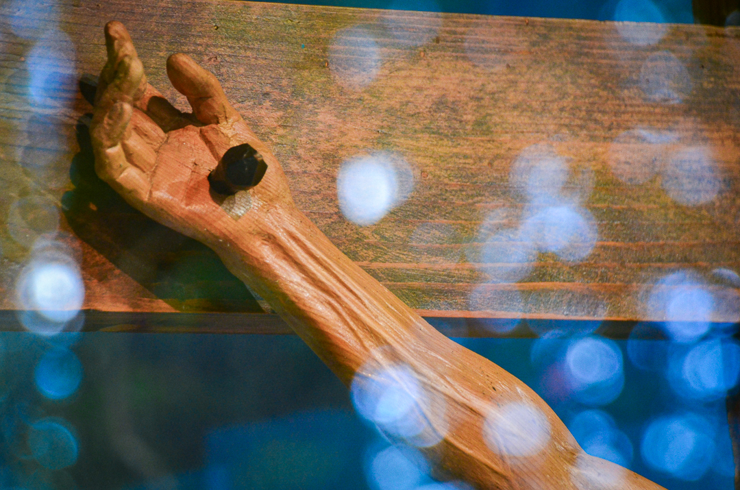 a closeup of the hand of a wooden crucifixion sculpture