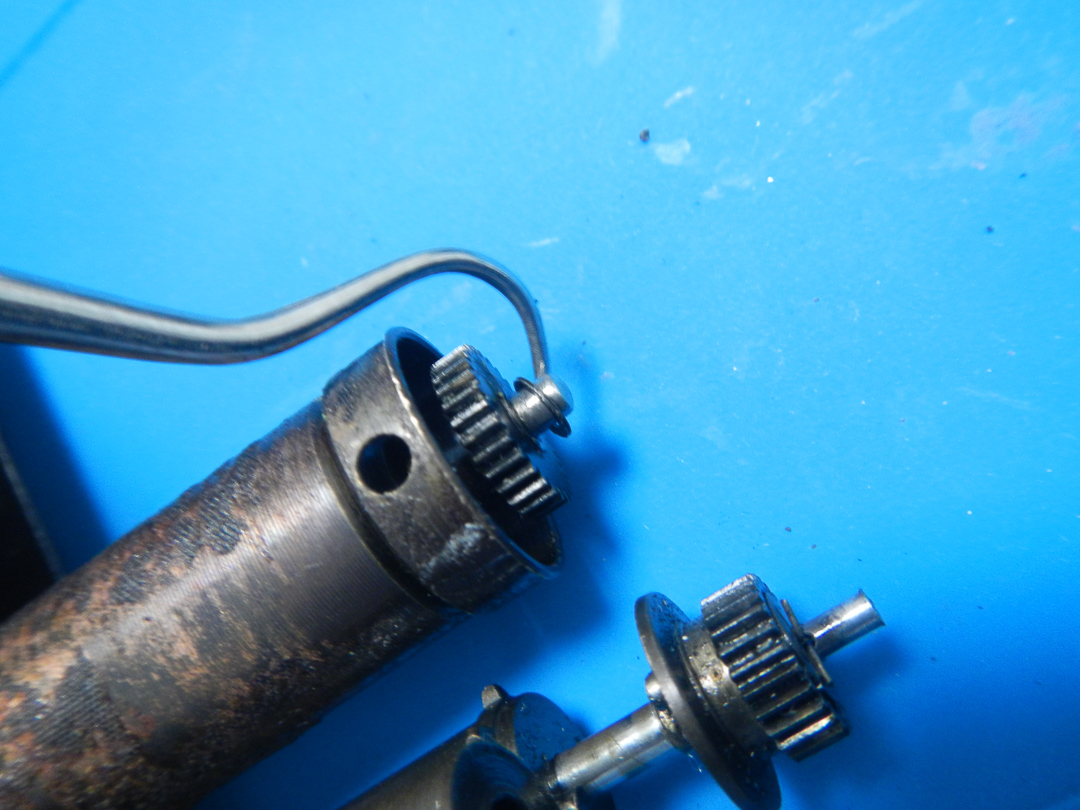 Roller end with its gear separated, hole visible in the tube wall